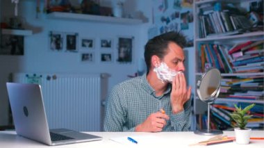 Ofis çalışanı masada tıraş olmaya başlar.