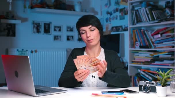 A woman makes a fan of money and starts waving near her face — Stock Video