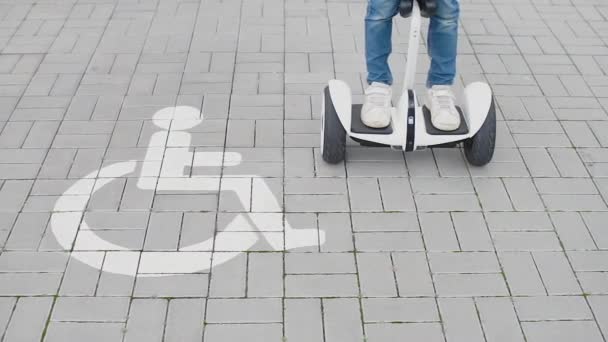 Utilização de um GyroScooter ao lado de uma pessoa com deficiência — Vídeo de Stock