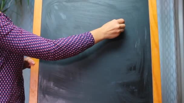 Hand draws chalked euro sign on blackboard — Stock Video