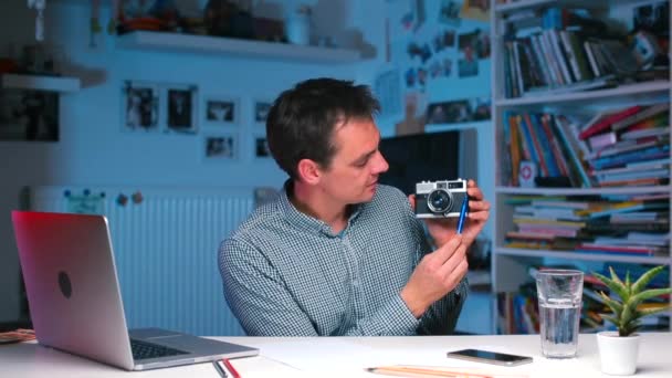 Un professeur de photographie dans une université montre un vieil appareil photo . — Video