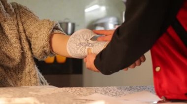 Usta, modelin elindeki dövmenin resmini deniyor.