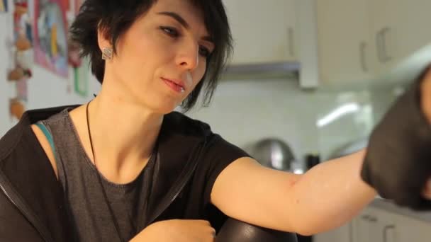 Tattoo meester wrijft hand crème meisje — Stockvideo