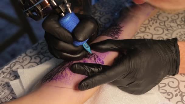 Spécialiste dessine un tatouage sur son bras — Video