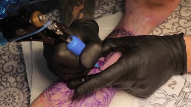 Mästare i svarta handskar gör en tatuering — Stockvideo