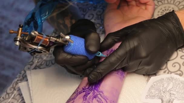 Мастер делает татуировку на руке — стоковое видео