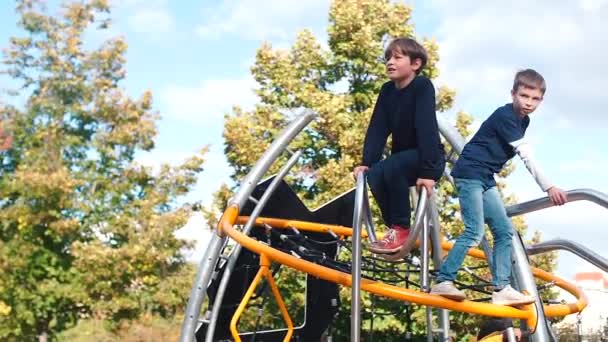 Três rapazes sobem ao parque infantil — Vídeo de Stock