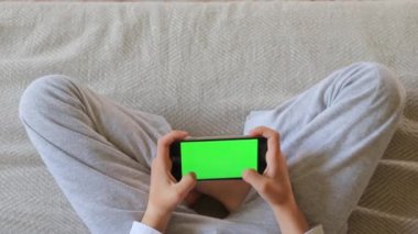 Çocuk telefonda oynuyor.