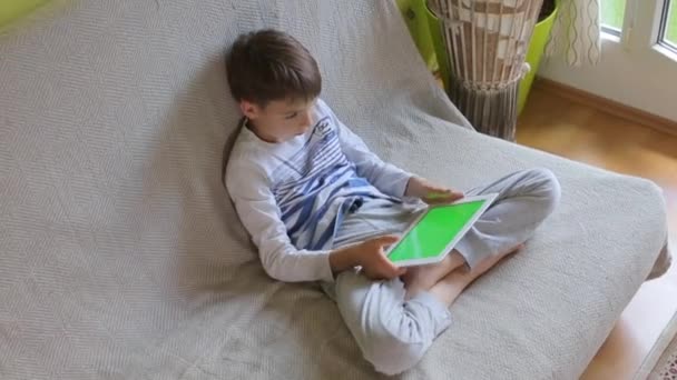 Boy uses tablet, plays — Stock Video