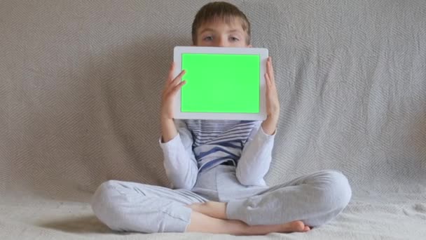 Chlapec se dívá zpoza tabletu — Stock video