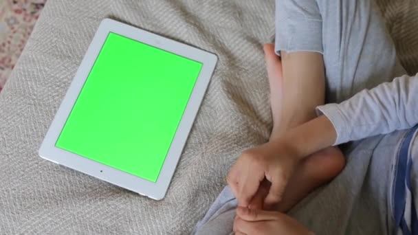 La tablette est couchée à côté de l'enfant — Video