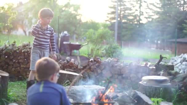 Two kids make fire, adventure — Stock Video