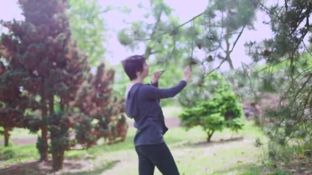 Meisje maakt gebruik van een smartphone in het park — Stockvideo