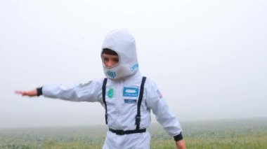 Astronot kılığındaki bir çocuk dairesel hareketler yapar..