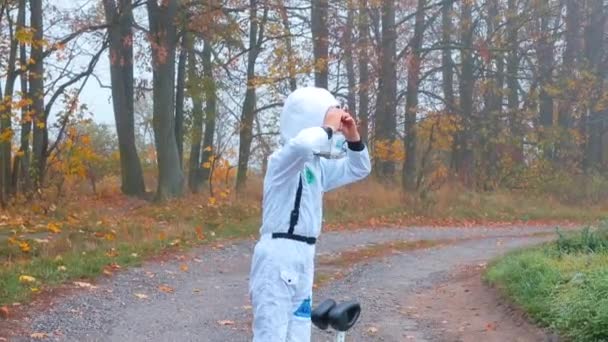 Een jongen in een astronautenkostuum verkent de planeet. — Stockvideo