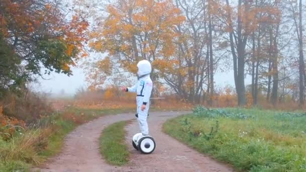 Astronot kostümü giymiş bir çocuk Dünya gezegeninin florasını keşfediyor.. — Stok video