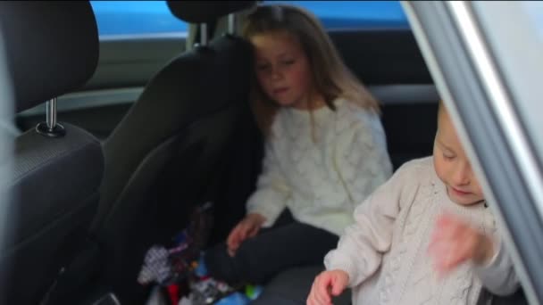 Barn sitter i baksätet på en bil. Förväntade föräldrar. — Stockvideo