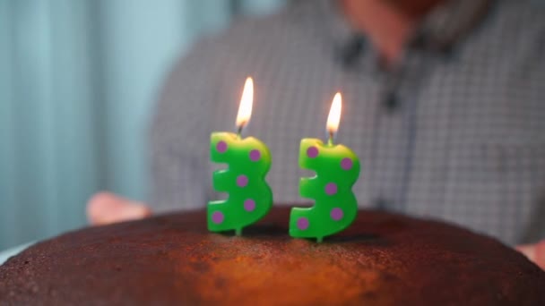 El tipo en su cumpleaños apaga las velas del pastel. . — Vídeos de Stock