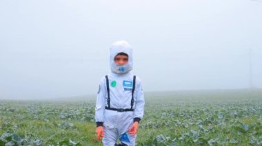 Astronot kostümü giymiş bir çocuk Dünya gezegenini inceliyor..