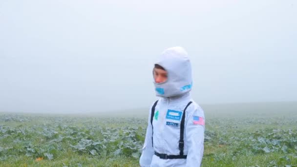 Um rapaz disfarçado de astronauta volta ao terreno — Vídeo de Stock