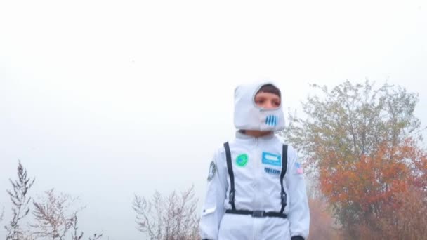 Хлопчик у костюмі космонавта шукає свій космічний корабель . — стокове відео