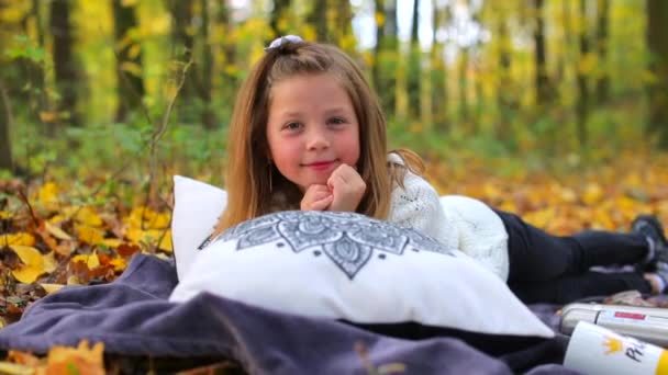 Mooi meisje op een picknick ligt in de herfst bos. — Stockvideo