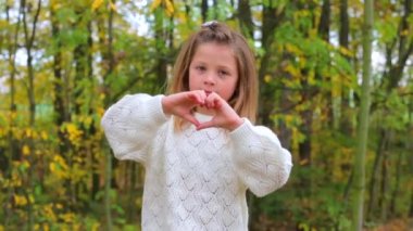 Sonbahar ormanında poz veren beyaz elbiseli bir kız..