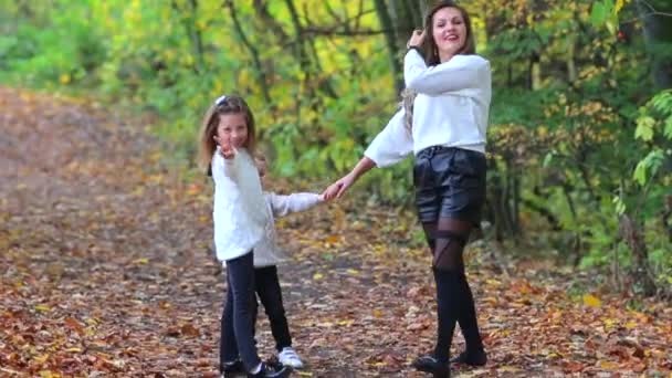 Máma se svým synem a dcerou procházka v podzimním lese v městském parku. — Stock video