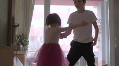 Captivating scenes of siblings enjoying a fun dance session in a cozy living room, showcasing the joy of childhood and playful bonding.