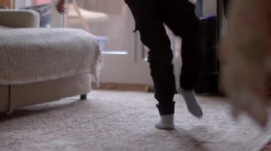 A child joyfully dances in a cozy living room, showcasing playful movement on soft carpet, capturing the essence of childhood joy and comfort indoors.