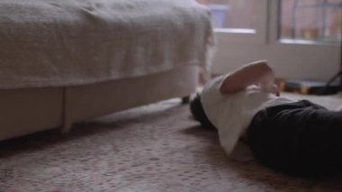 A young child lounging on the floor, relaxed and contemplative in a cozy living room environment, with soft lighting and a warm atmosphere.