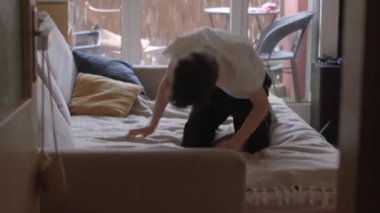 A child enjoys joyful moments while playing in a cozy living room. The soft decor exudes warmth and creativity in a relaxed indoor space.