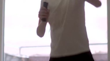 A young boy passionately performs and sings at home, holding a microphone. His energetic performance captures the spirit of creativity and joy in a bright, inviting space.