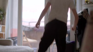 A young boy joyfully exploring his living space, showcasing playful energy and curiosity. Captured in a bright, inviting environment.