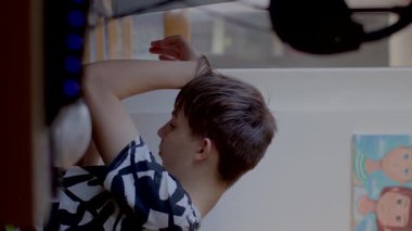 A young man is peacefully resting his head on his arm while savoring a refreshing drink in the comfort of his home