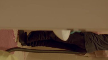 A young boy is creatively using a vacuum cleaner in a fun and engaging way during an indoor cleaning session at home