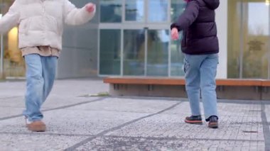 A lively urban scene showcases diverse individuals enjoying a vibrant sidewalk. Joyful adults walk by a stunning building, while kids laugh nearby