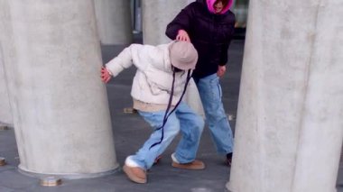 This vibrant video showcases couples in an urban setting. A woman in a pink hat and a man in a white jacket share playful glances