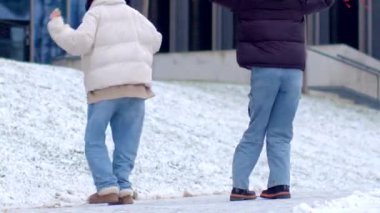 A man, a woman, and a child stroll through a snowy landscape, sharing joyful moments and warm conversations, creating cherished memories