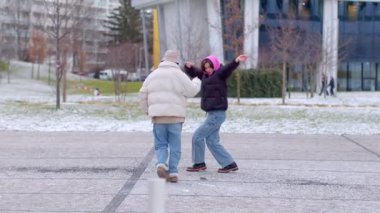 In this joyful winter video, a couple dances in a snowy landscape, showcasing love and celebration against charming backdrops
