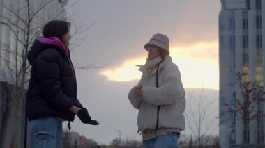 This vibrant video shows people connecting, featuring two women sharing a joyful high five and a heartwarming moment of friendship