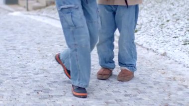 A heartwarming winter scene unfolds as a couple walks hand in hand with a child, sharing laughter in the snowy ambiance, surrounded by soft flurries
