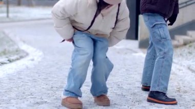 In a winter landscape, a heartwarming love story unfolds as couples revel in snow. A woman kneels to propose, creating a touching scene