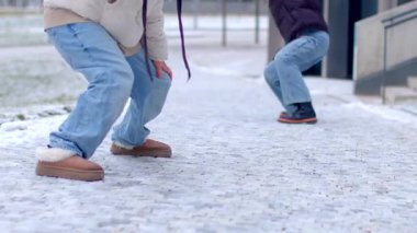 A man and woman enjoy a snowy day together, laughing and sharing joy. They playfully engage with the snow, embodying warmth in the cold