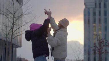 This heartwarming video shows two girls and a couple sharing joy, from playful snow interactions to sunset silhouettes, celebrating love