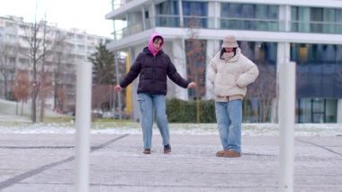 A lively urban scene shows a couple on a busy sidewalk. People dance, reflecting community spirit, while a man and woman share a moment