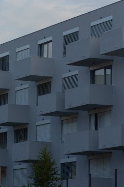 Contemporary apartment complex featuring unique balcony designs and large windows, showcasing modern urban living.