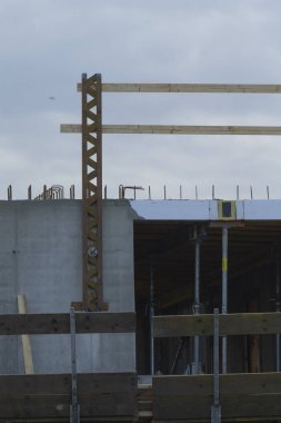 Ahşap iskelet ve inşaat altında beton duvarların yer aldığı bir inşaat alanının ayrıntılı görüntüsü.