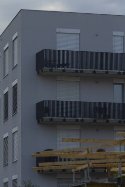 A sleek modern apartment building featuring balconies, captured during construction, showcasing contemporary architecture.