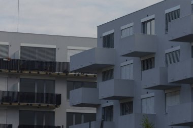 A striking view of a modern apartment complex featuring sleek balconies and minimalist architecture, ideal for urban living.
